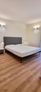 a large bed in a room with a wooden floor at Ville Lazise Ada & Rico in Lazise