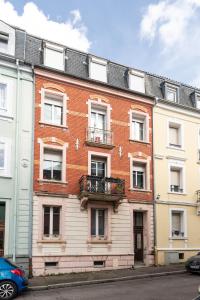 un gran edificio de ladrillo con balcones en una calle en Appartement entièrement rénové et cosy avec jardin, en Mulhouse