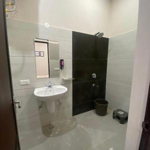 a bathroom with a sink and a mirror at Wellawing Residency in Ludhiana
