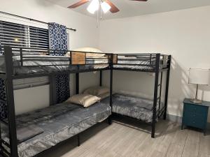 two bunk beds in a room with a ceiling fan at Bekahouse Hostel with parking, backyard and laundry in Miami