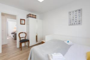 um quarto branco com uma cama e uma cadeira em Iñaki Deuna - baskeyrentals em Ondárroa