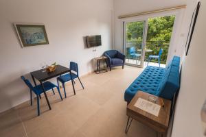 a living room with a blue couch and a table and chairs at Chrielka Hotel in Limassol