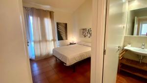 a bedroom with a bed and a bathroom with a sink at Acogedor apartamento con altillo MSJ 53 in Calafat