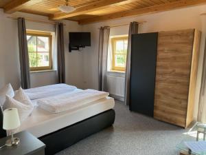 a bedroom with a large bed and a tv at Landgasthof Brandtner Wirt in Langdorf