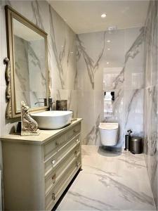 a bathroom with a sink and a mirror and a toilet at Tranquil chic retreat in Heraklio