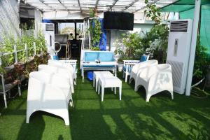 a group of white chairs and tables in a garden at Rockville House managed & operated by Serai Boutique Hotels and Resorts in Islamabad