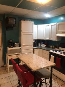 a kitchen with a wooden table and white cabinets at A Hidden Gem, approx 15 mins to downtown Chicago! in Chicago