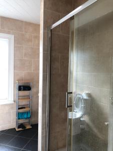 a shower with a glass door in a bathroom at Comfortable home, town centre, free parking,Multiple Rooms in Cheltenham