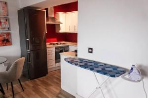 a kitchen with a black refrigerator and a counter top at Cozy and Modern 2-bed apartment in Swansea