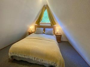a bedroom with a bed and a window in a attic at Coastal View in Kingsdown