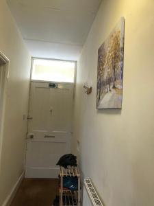 a hallway with a door and a painting on the wall at Comfortable home, town centre, free parking,Multiple Rooms in Cheltenham