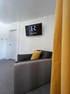 a couch in a room with a sign on the wall at Royal Suites Kirkcudbright in Kirkcudbright