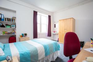 a bedroom with a bed and a desk and a window at McIntosh Hall Campus Accommodation in St. Andrews