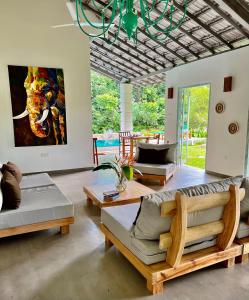 a living room with a couch and tables and a painting at The Jungle Loft Galle in Galle