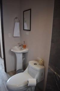 y baño con aseo y lavamanos. en Casa Luna, espacio moderno y acogedor, en Liberia