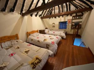 3 Betten in einem Zimmer mit Holzböden in der Unterkunft Cabaña con excelente ubicación y zona verde. in Iza