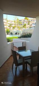 een tafel en stoelen in een kamer met een raam bij GOLF DEL SUR ALBATROS 5 bed places apartment in San Miguel de Abona
