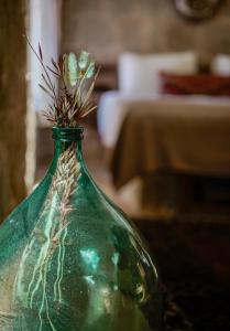 eine grüne Glasvase mit einer Blume darin in der Unterkunft Doda Artisanal Cave Hotel 14 Plus in Ortahisar + 44 Fotos