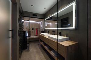 a bathroom with two sinks and a large mirror at Salzkammergut Lodge in Ebensee