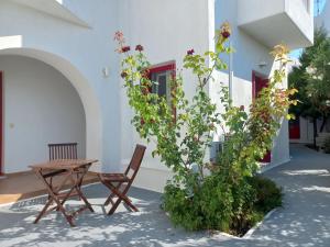 ein Holztisch und ein Stuhl neben einem Gebäude in der Unterkunft Solid Residence in Triovasálos + 19 Fotos