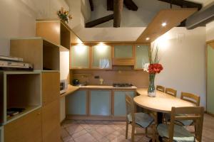 a kitchen with a table with a vase of flowers at I Gioielli del Doge - Cannaregio in Venice