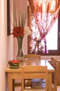 una mesa de comedor con un jarrón de flores. en I Gioielli del Doge - Cannaregio, en Venecia