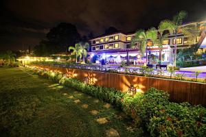 une maison avec des lumières sur une clôture la nuit dans l'établissement Hotel Tropika, à Davao