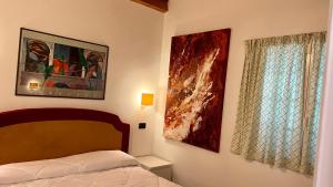 een slaapkamer met een bed en twee foto's aan de muur bij Villette Aldobrandeschi Urban Oasis Vacation Homes in Rome