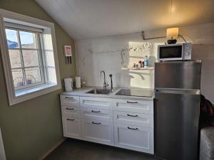 La cuisine est équipée d'un réfrigérateur en acier inoxydable et d'un évier. dans l'établissement Apartment for 4 guests, à Hvolsvöllur