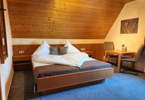 Schlafzimmer mit einem Bett mit Holzdecke in der Unterkunft Hotel Klett B&B in Langenargen