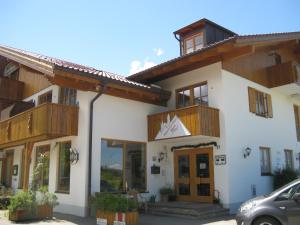 een gebouw met houten balkons en een auto geparkeerd aan de voorzijde bij Alpenhotel Allgäu in Hohenschwangau