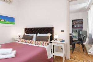 een slaapkamer met een groot roze bed en een bureau bij Corso Vittorio Apartments in Rome