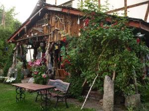 ein Holzhaus mit einem Tisch und Blumen in der Unterkunft Pensjonat Kalina Komorze in Komorze