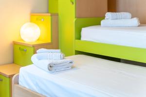 ein Zimmer mit 2 Betten und weißen Handtüchern darauf in der Unterkunft The Veranda Holiday in Badesi