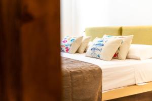 una cama con almohadas blancas encima en The Veranda Holiday, en Badesi