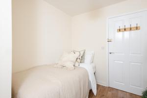 um quarto com uma cama com lençóis brancos e uma porta em Luxury Apartment, Birmingham-Parking em Birmingham
