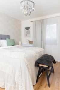 a white bedroom with a bed and a chandelier at Luxury Apartment, Birmingham-Parking in Birmingham