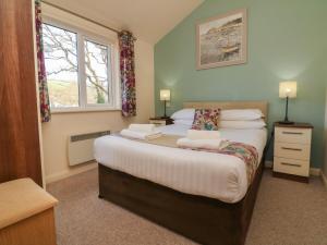 um quarto com 2 camas e uma janela em Chalet Log Cabin L2 em Ilfracombe