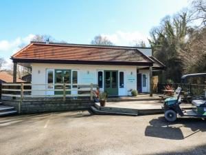 a house with a car parked in front of it at Chalet Log Cabin L2 in Ilfracombe