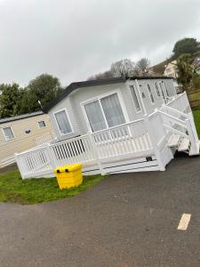 a mobile home with a white porch and stairs at The avenue, Waterside in Paignton