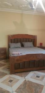 a bedroom with a wooden bed in a room at The bb's in Brusubi