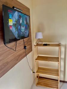 a flat screen tv hanging on a wall at Quartos Dossel - Sítio Belo Monte in Pacoti