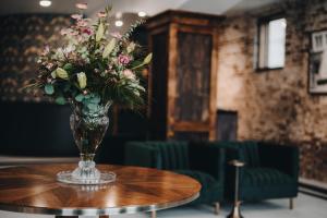 un vaso di fiori seduto sopra un tavolo di The Chandler Hotel a Madison