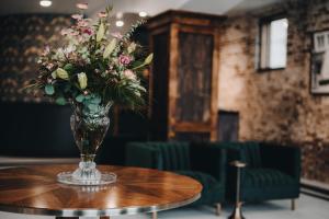 wazon kwiatów siedzący na stole w obiekcie The Chandler Hotel w mieście Madison
