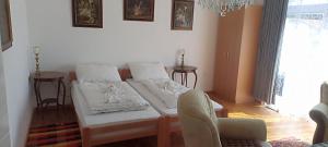a room with a bed with white sheets and a chair at SOBE KOD TETA MILKE in Veliko Gradište