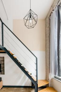 a staircase in a house with a chandelier at Le Charmant Hypercentre tram design in Saint-Étienne