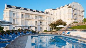 a hotel with a pool in front of a building at Gran Hotel Suances in Suances