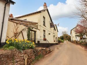 a house with flowers on the side of a road at Woodpecker Lodge in Cullompton