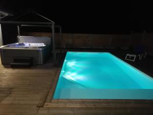 una piscina blu in una camera buia di Magnifique Villa sur le Bassin d'Arcachon - JACUZZI+PISCINE - 8à10pers a Biganos