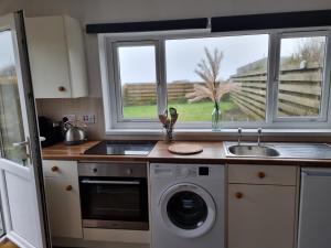 a kitchen with a sink and a washing machine at Seaview in Trevilley